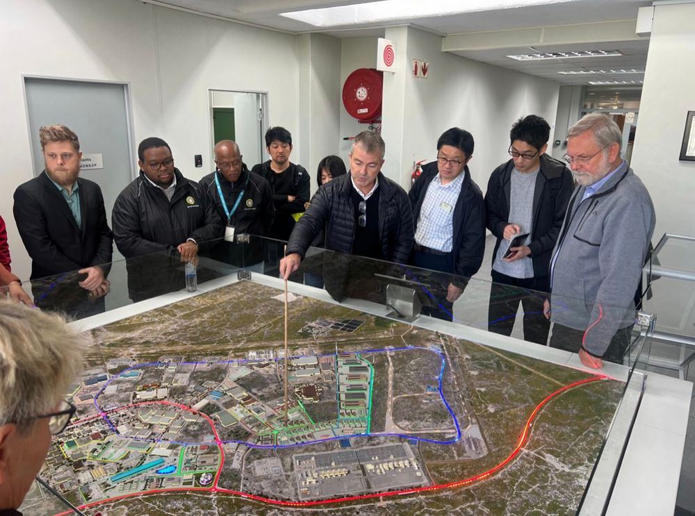 A delegation reviews a zone masterplan during a site visit