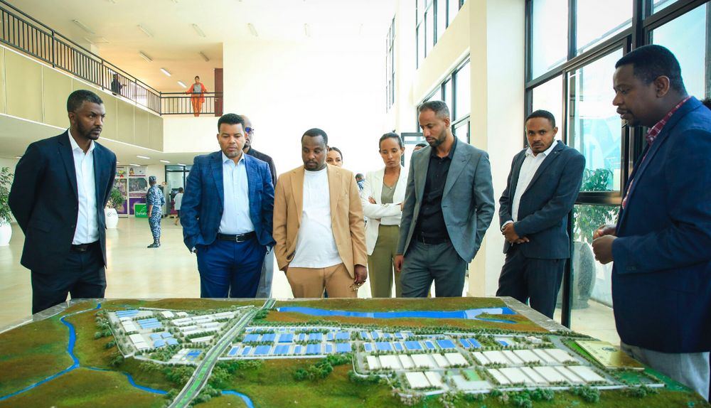 Delegates review a zone masterplan model during a site visit